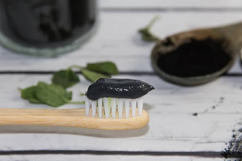 Charcoal toothpaste on toothbrush